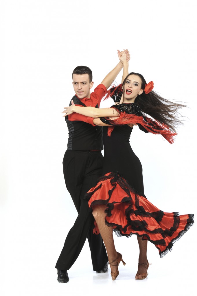 Costumed couple performing flamboyant ballroom dance
